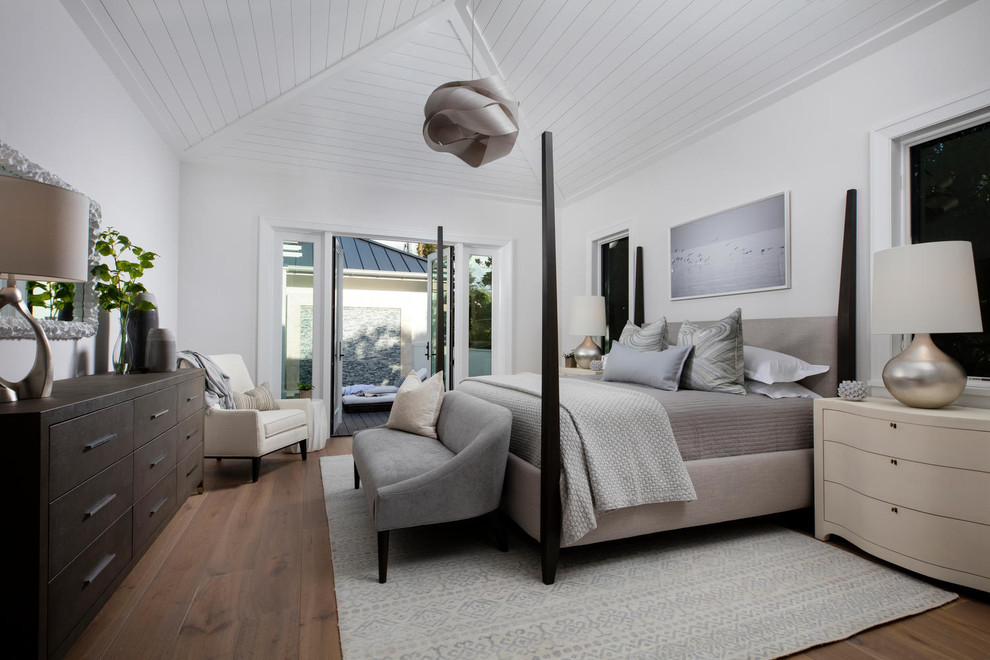 Modelo de dormitorio principal tradicional renovado con paredes blancas, suelo de madera en tonos medios y suelo marrón