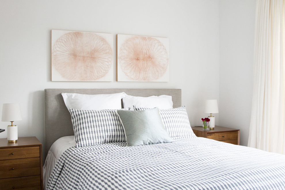 Imagen de habitación de invitados actual de tamaño medio con paredes blancas y suelo de madera en tonos medios