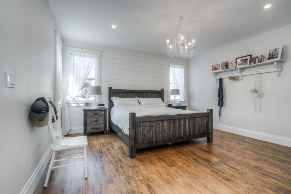 Mittelgroßes Country Hauptschlafzimmer mit weißer Wandfarbe, Keramikboden, Kamin, Kaminumrandung aus Holzdielen und schwarzem Boden in Toronto