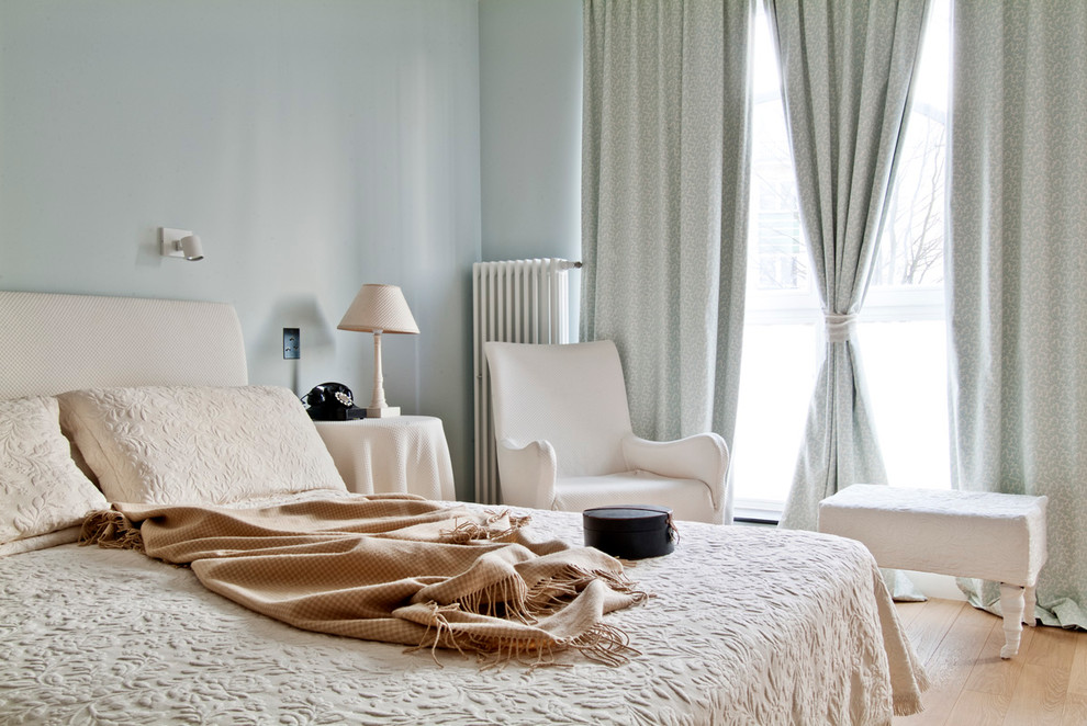 Modelo de dormitorio contemporáneo con paredes grises y suelo de madera clara