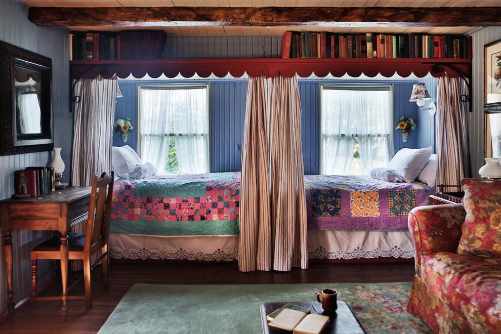 This is an example of a farmhouse guest bedroom in St Louis with blue walls and dark hardwood flooring.