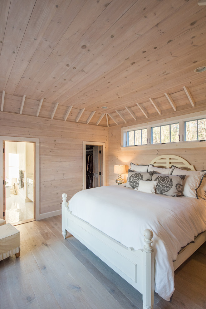 Imagen de dormitorio principal rústico de tamaño medio sin chimenea con paredes beige, suelo de madera clara y suelo beige