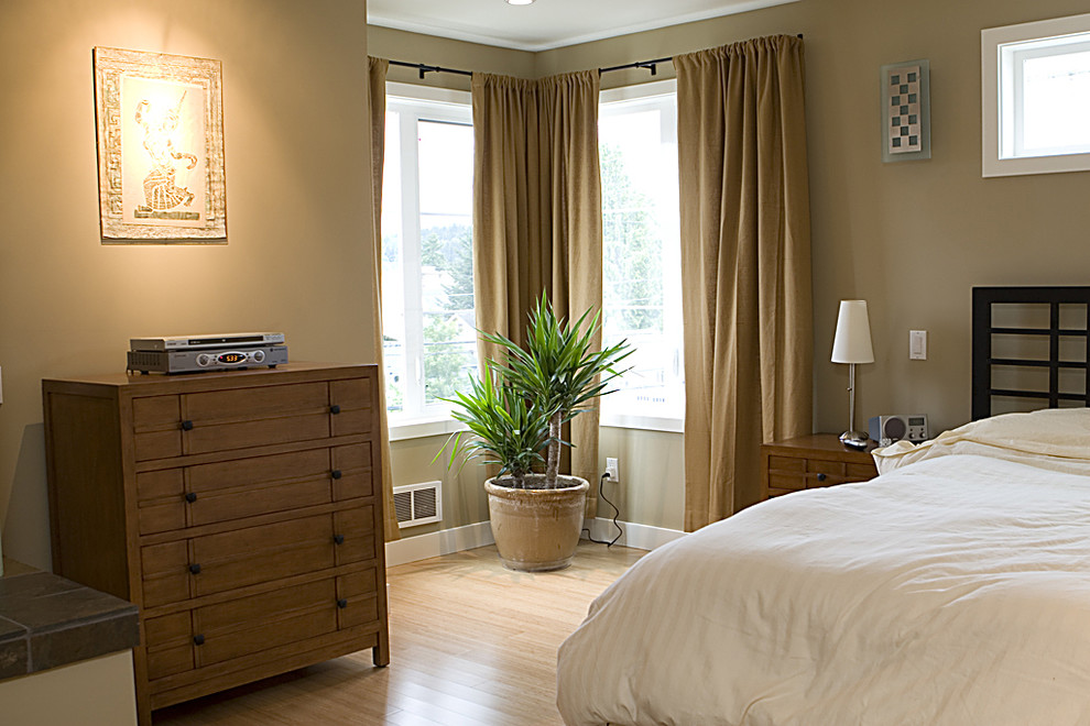 Diseño de dormitorio actual sin chimenea con paredes beige y suelo de madera clara