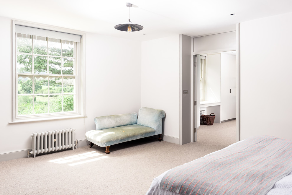 Großes Modernes Hauptschlafzimmer ohne Kamin mit weißer Wandfarbe, Teppichboden, Kaminumrandung aus Backstein und beigem Boden in Sussex