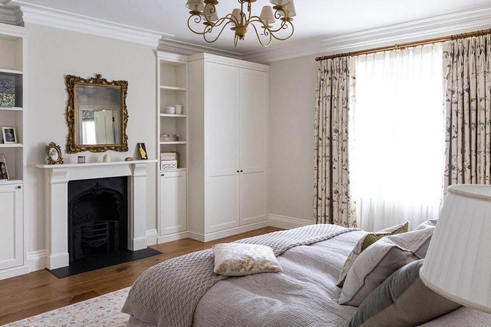 Immagine di una camera da letto vittoriana con pareti beige e pavimento marrone
