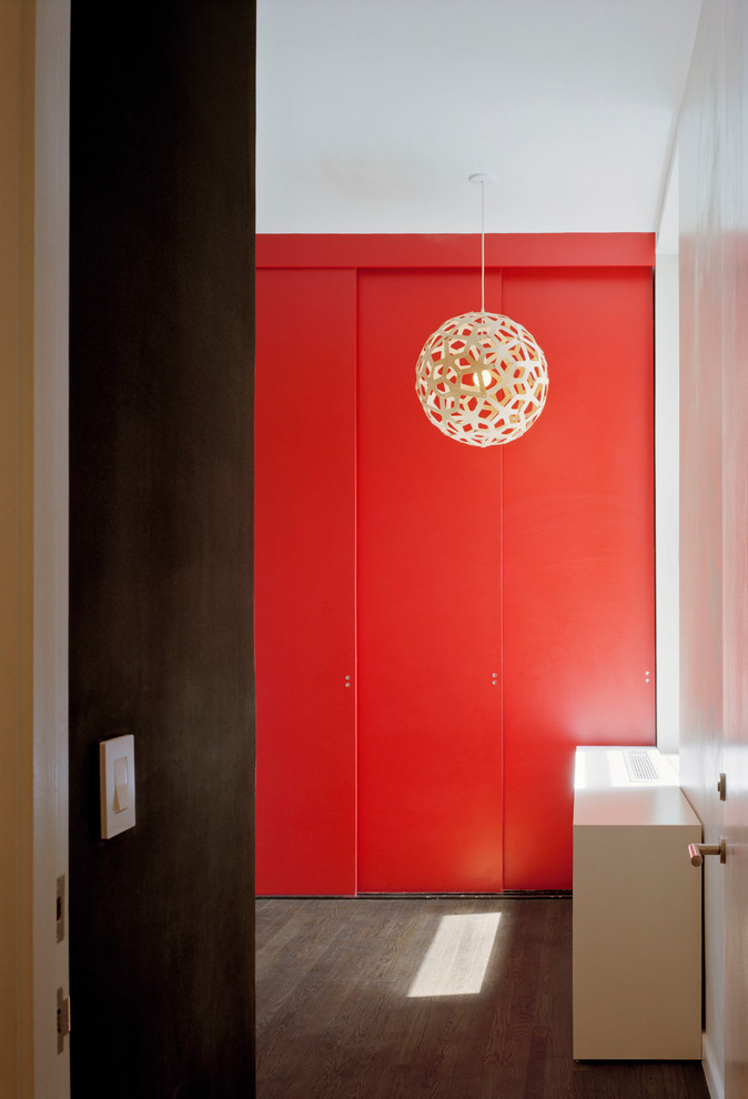 Modelo de habitación de invitados minimalista de tamaño medio con paredes rojas, suelo de madera oscura y suelo marrón