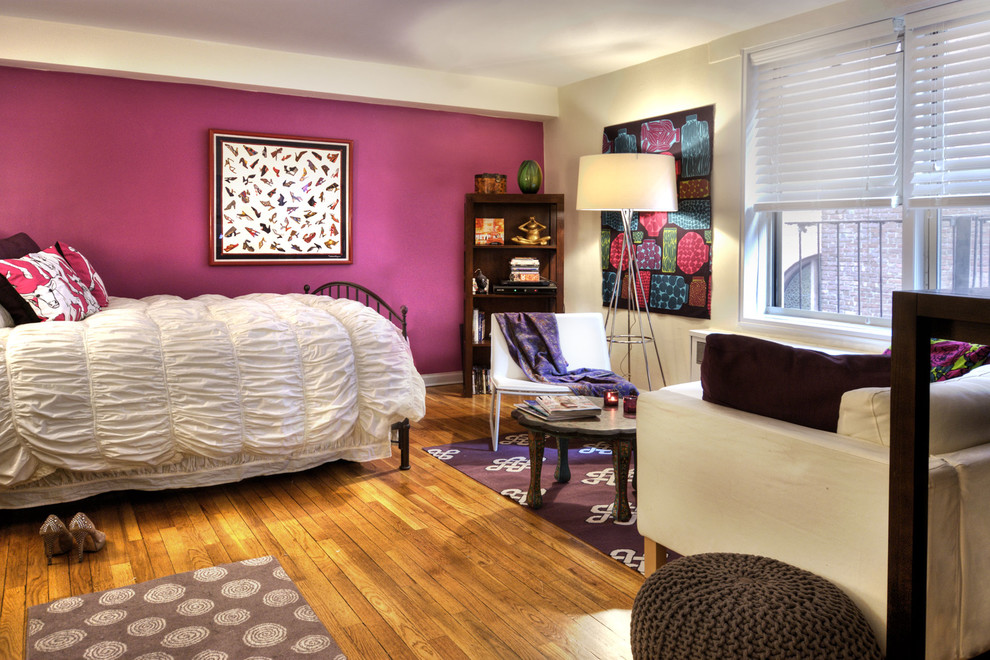 Esempio di una camera degli ospiti boho chic di medie dimensioni con pareti rosa, pavimento in legno massello medio e pavimento beige