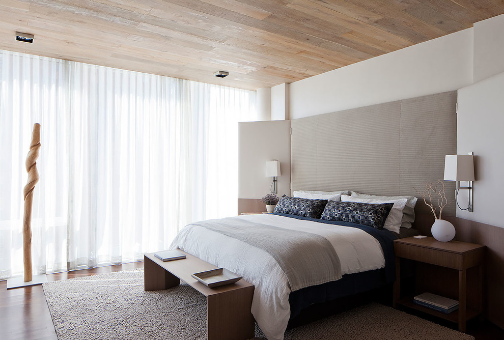 На фото: хозяйская спальня в современном стиле с паркетным полом среднего тона, белыми стенами и тюлем
