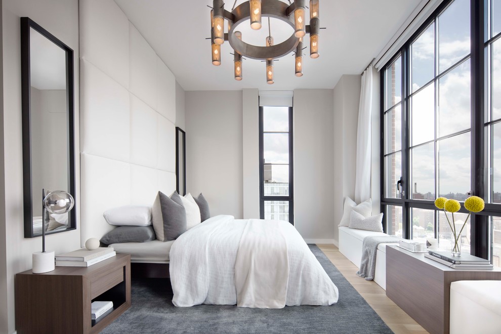 ニューヨークにあるコンテンポラリースタイルのおしゃれな主寝室 (グレーの壁、淡色無垢フローリング、暖炉なし) のインテリア
