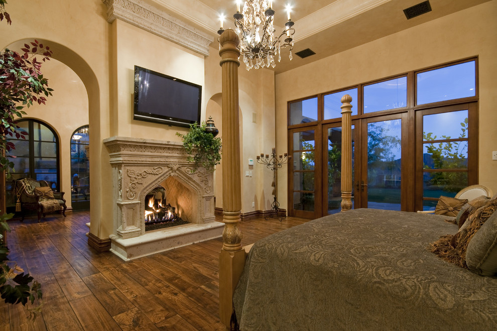 フェニックスにある巨大な地中海スタイルのおしゃれな寝室 (ベージュの壁、トラバーチンの床、標準型暖炉、石材の暖炉まわり) のレイアウト