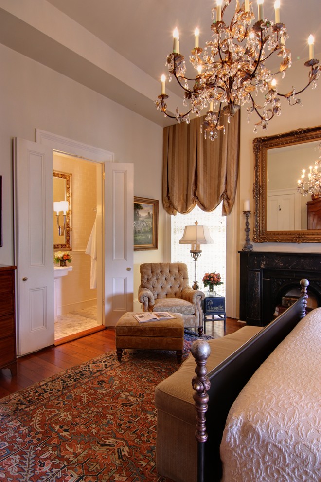 Diseño de habitación de invitados clásica grande con paredes beige, suelo de madera oscura, todas las chimeneas y marco de chimenea de yeso