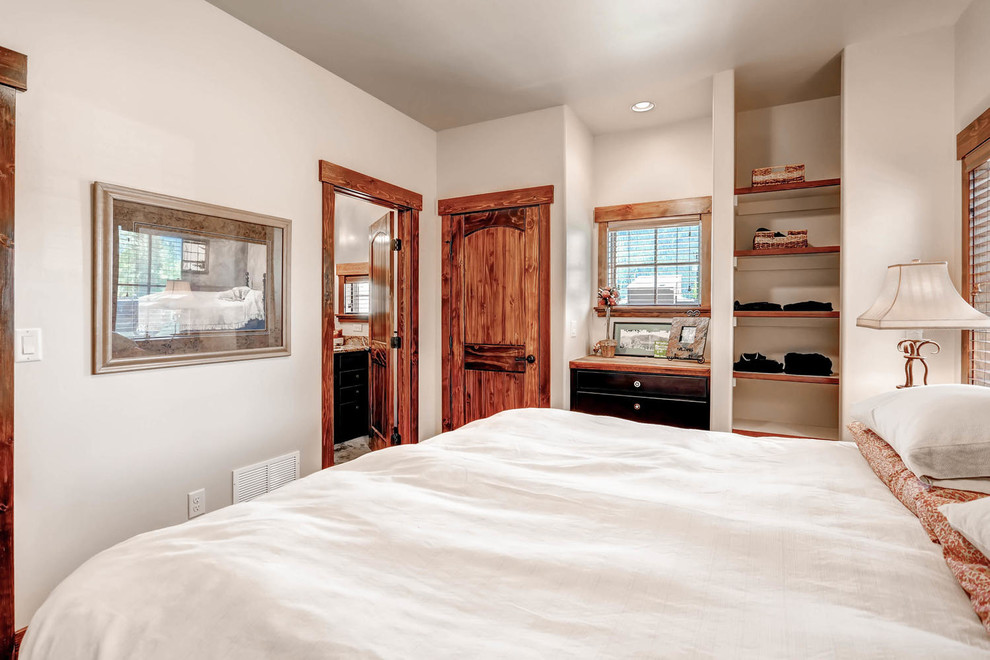 Modelo de dormitorio principal rústico de tamaño medio sin chimenea con paredes beige y moqueta