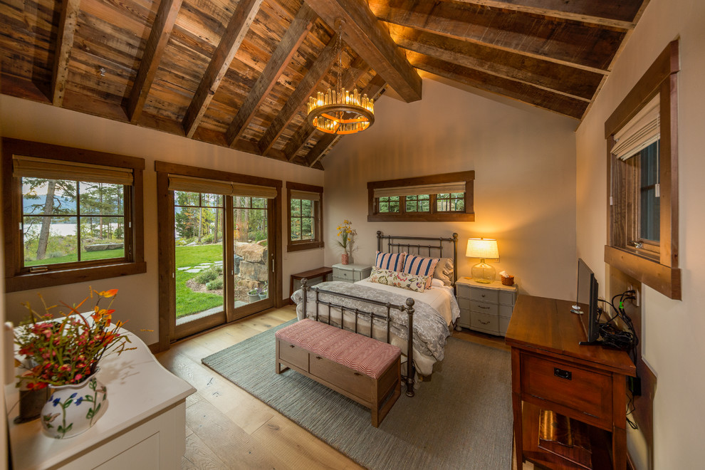 Foto de habitación de invitados rural de tamaño medio sin chimenea con paredes beige, suelo de madera clara y suelo beige