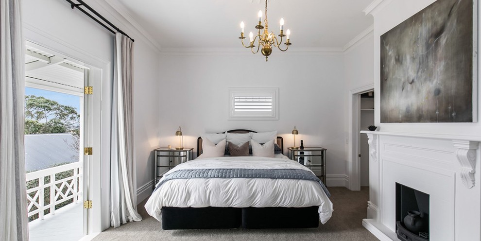 Пример оригинального дизайна: большая хозяйская спальня в викторианском стиле с белыми стенами, ковровым покрытием, стандартным камином, фасадом камина из дерева и серым полом