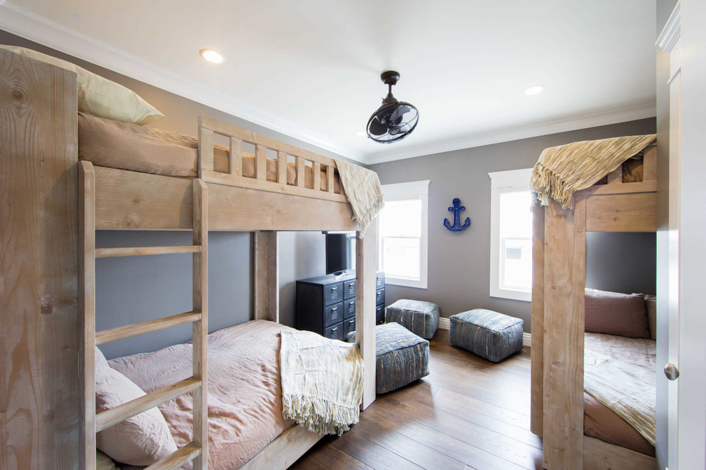 Example of a mid-sized beach style guest dark wood floor and brown floor bedroom design in San Luis Obispo with gray walls and no fireplace