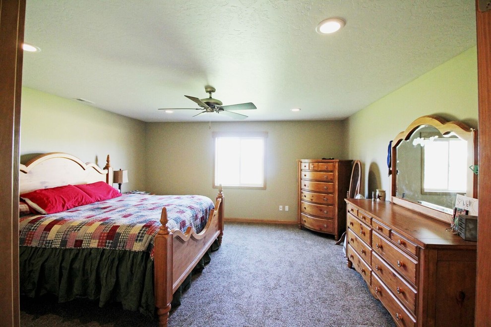 На фото: большая хозяйская спальня в классическом стиле с зелеными стенами, ковровым покрытием и серым полом без камина с