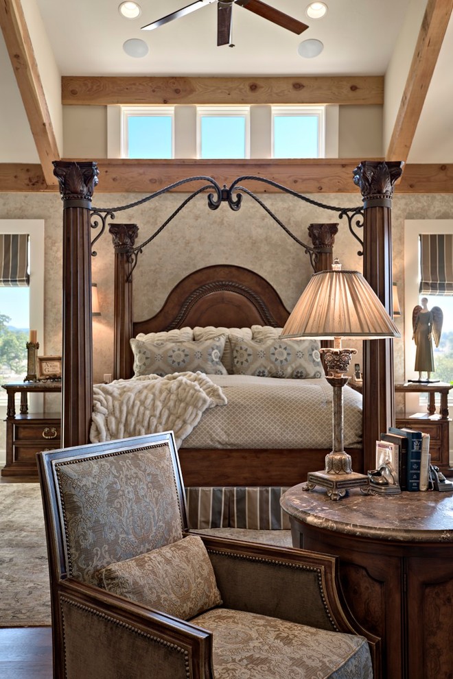 Exempel på ett stort klassiskt sovrum, med beige väggar, mörkt trägolv, en standard öppen spis och en spiselkrans i trä