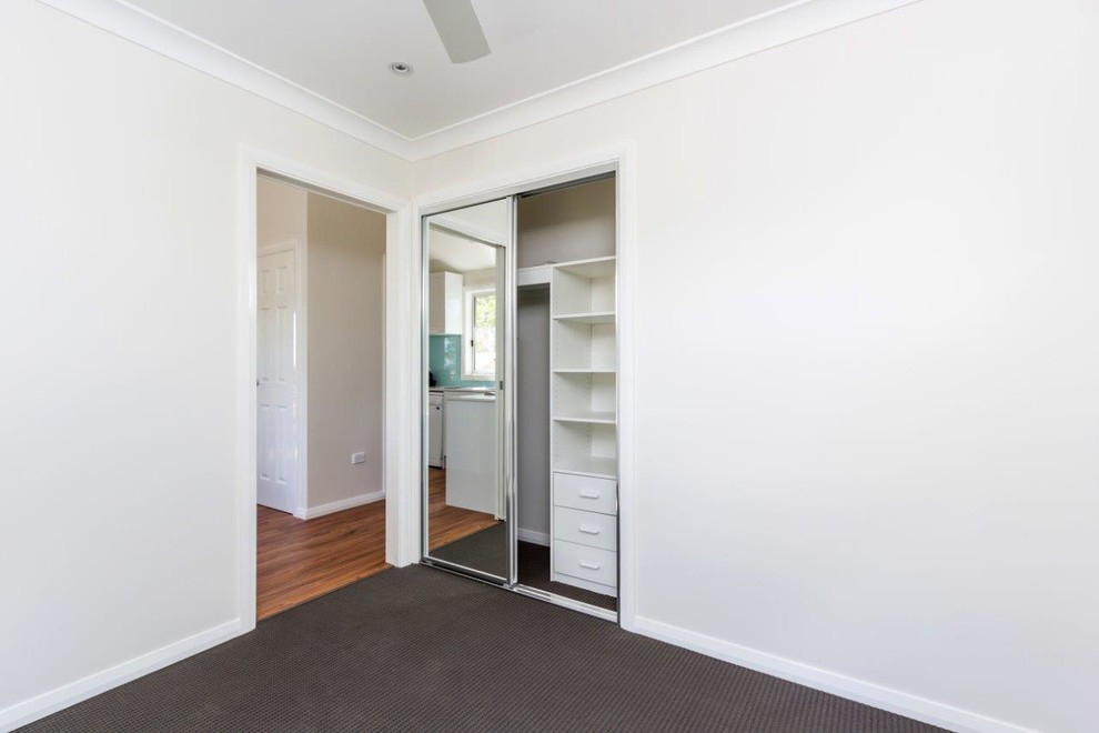 Kleines Modernes Schlafzimmer mit weißer Wandfarbe und Teppichboden in Sydney