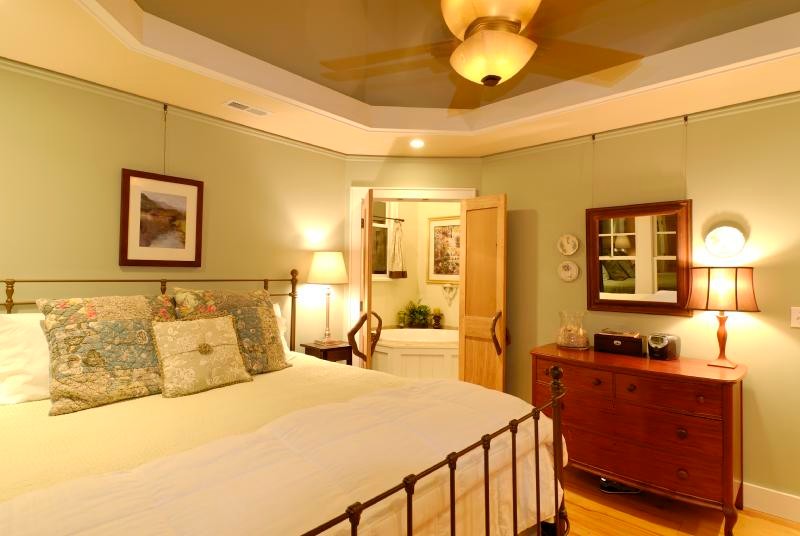 Imagen de dormitorio principal de estilo americano de tamaño medio sin chimenea con suelo de madera clara