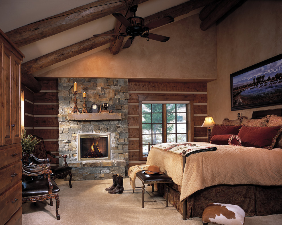 Imagen de dormitorio rústico de tamaño medio con paredes beige, moqueta, todas las chimeneas y marco de chimenea de piedra