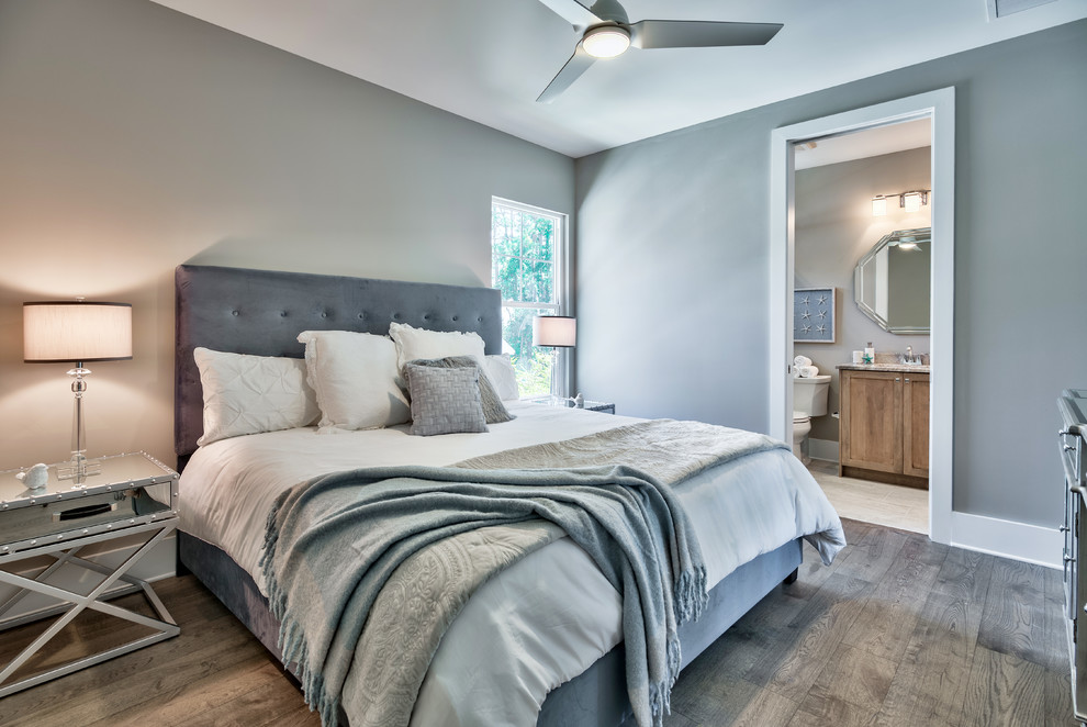 Modelo de dormitorio principal marinero de tamaño medio sin chimenea con paredes grises, suelo de madera en tonos medios y suelo gris