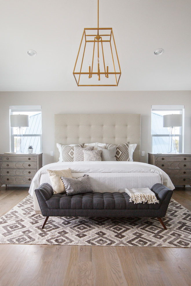 Imagen de dormitorio principal clásico renovado grande con paredes beige, suelo de madera en tonos medios, todas las chimeneas, marco de chimenea de baldosas y/o azulejos y suelo beige