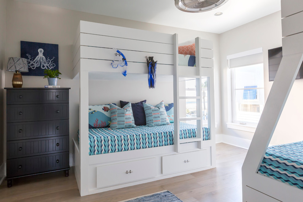 Modelo de habitación de invitados costera de tamaño medio con paredes beige y suelo de madera clara