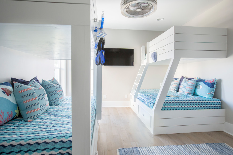 Ejemplo de habitación de invitados marinera de tamaño medio con paredes beige y suelo de madera clara