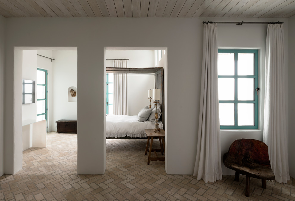 Mittelgroßes Mediterranes Gästezimmer ohne Kamin mit weißer Wandfarbe und Backsteinboden in Houston