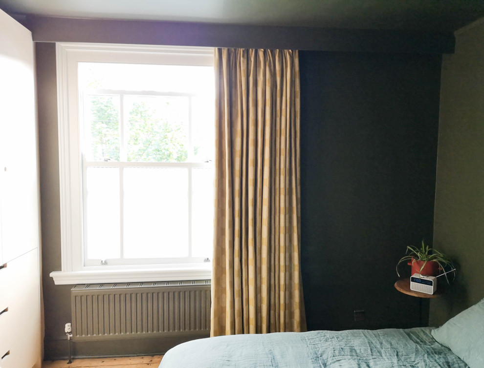 Ejemplo de dormitorio principal contemporáneo pequeño con paredes verdes y suelo de madera en tonos medios