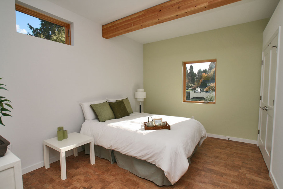 Diseño de habitación de invitados actual de tamaño medio con paredes blancas y suelo de corcho