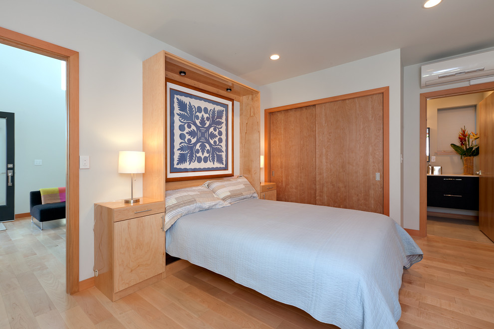 На фото: гостевая спальня (комната для гостей) в современном стиле с белыми стенами и светлым паркетным полом без камина с