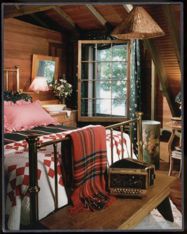 Cette image montre une petite chambre parentale chalet avec un mur marron, parquet foncé, une cheminée standard et un manteau de cheminée en pierre.