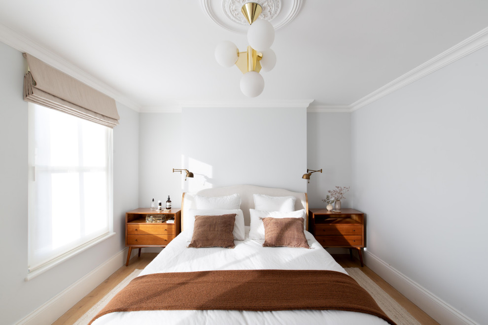 Modelo de dormitorio principal tradicional renovado de tamaño medio sin chimenea con paredes grises, suelo de madera clara y suelo beige