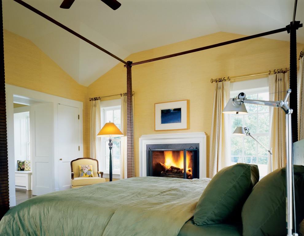 Идея дизайна: спальня в стиле кантри с желтыми стенами и стандартным камином