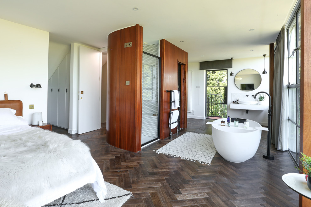 Aménagement d'une grande chambre parentale éclectique avec un mur blanc, parquet foncé et un sol marron.