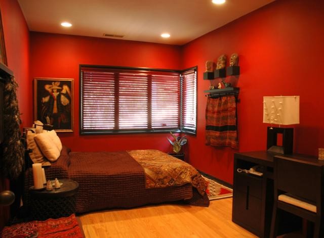 Ispirazione per una camera degli ospiti design di medie dimensioni con pareti rosse, parquet chiaro e pavimento marrone