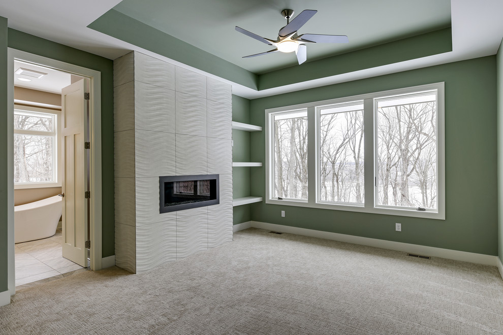 Пример оригинального дизайна: хозяйская спальня среднего размера в современном стиле с зелеными стенами, ковровым покрытием, стандартным камином, фасадом камина из плитки и серым полом