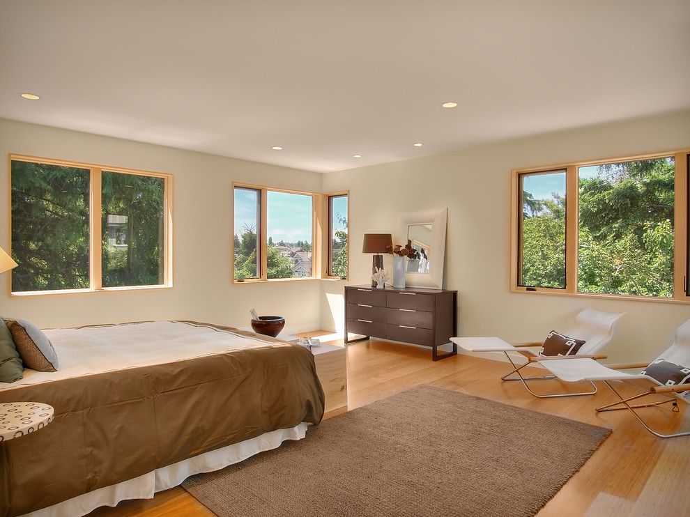 Imagen de dormitorio principal minimalista de tamaño medio con paredes beige y suelo de bambú