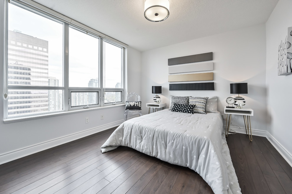 Photo of a medium sized contemporary master bedroom in Toronto with grey walls, laminate floors, no fireplace and brown floors.