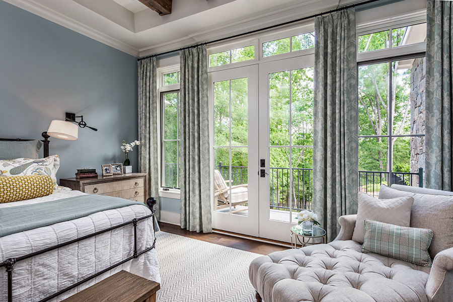 Foto de dormitorio principal de estilo de casa de campo grande con paredes azules, suelo de madera en tonos medios y suelo marrón