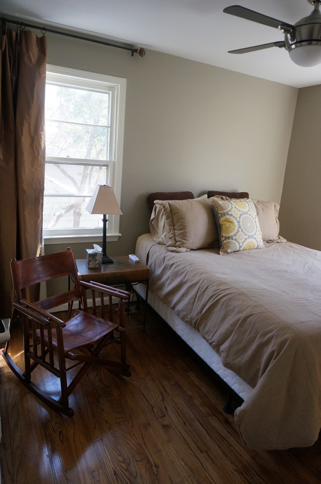 Immagine di una camera da letto tradizionale con pareti grigie e pavimento in legno massello medio