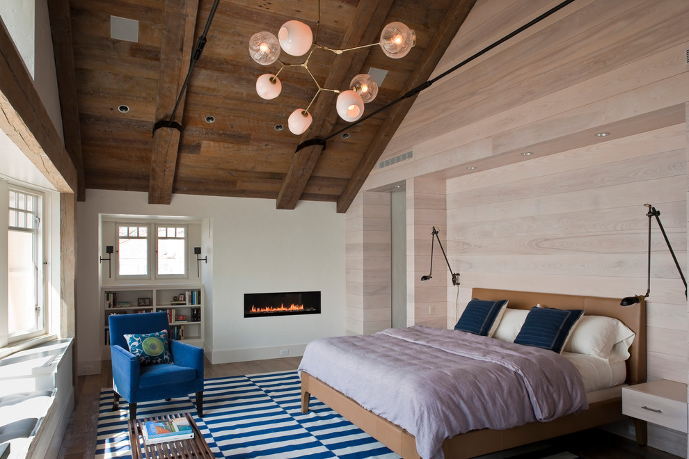 Foto de dormitorio ecléctico con suelo de madera en tonos medios y chimenea lineal