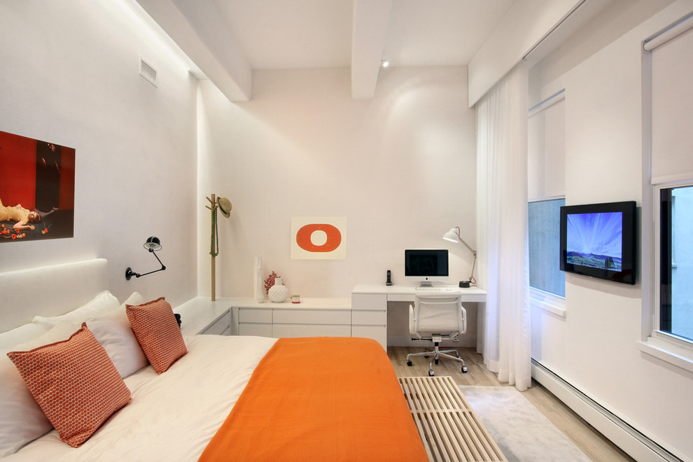 This is an example of a contemporary bedroom in New York with white walls and light hardwood flooring.