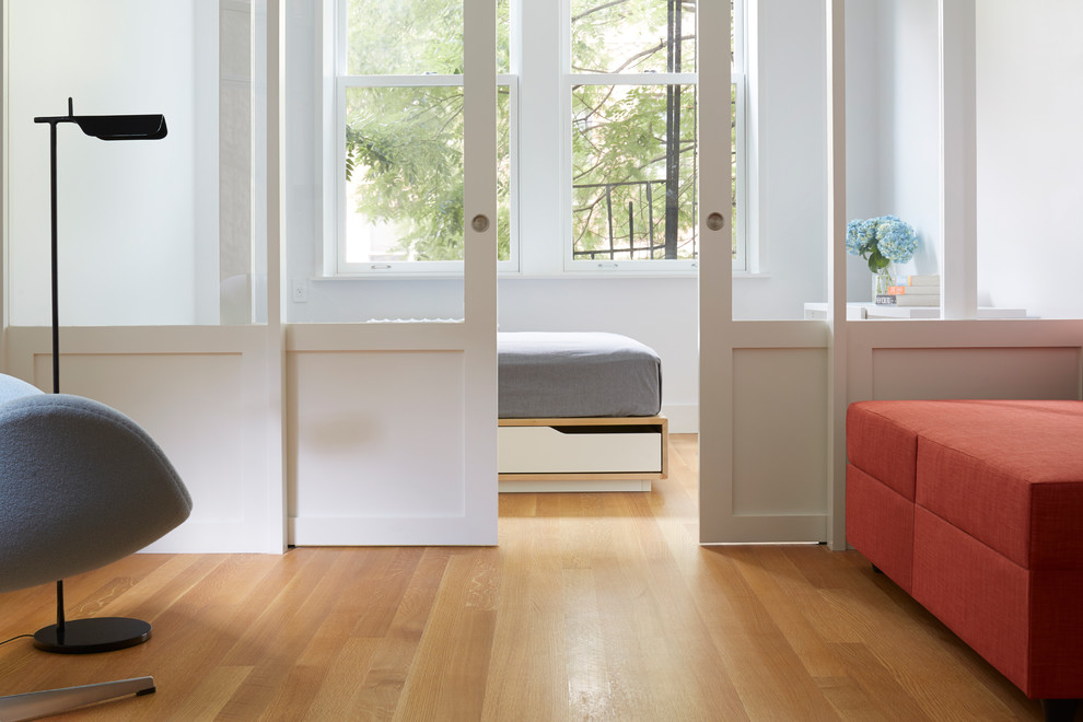 Diseño de dormitorio escandinavo pequeño con paredes blancas y suelo de madera en tonos medios