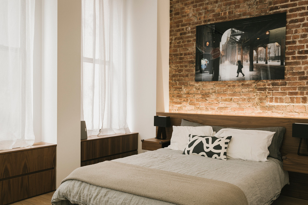 Industrial Hauptschlafzimmer ohne Kamin mit braunem Holzboden und beiger Wandfarbe in New York