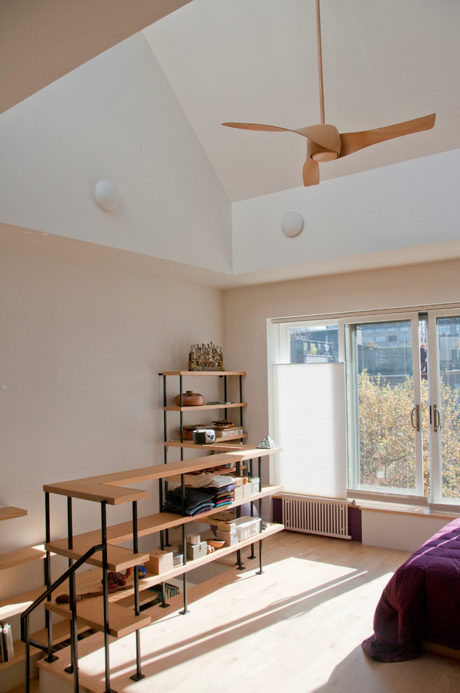 Ejemplo de habitación de invitados actual de tamaño medio con paredes blancas y suelo de madera clara