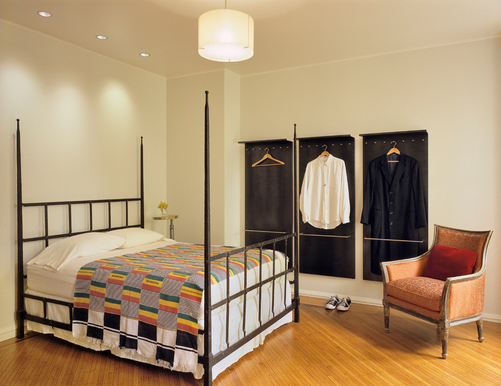 Imagen de dormitorio bohemio con paredes beige y suelo de madera en tonos medios