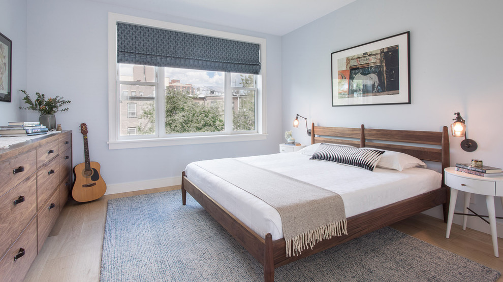 ニューヨークにある中くらいなモダンスタイルのおしゃれな主寝室 (青い壁、淡色無垢フローリング、茶色い床)