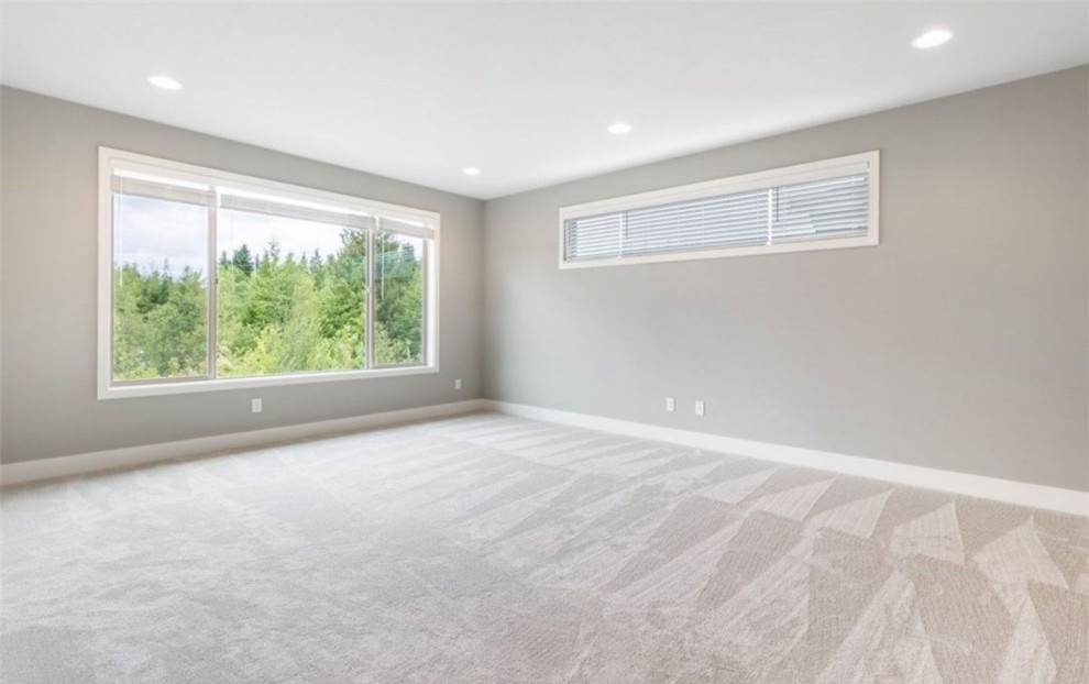 Photo of a large modern master bedroom in Portland with grey walls, carpet and grey floors.